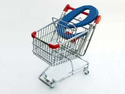 A miniature shopping cart isolated on white with a blue letter "E" in the basket depicting e-commerce or online shopping.