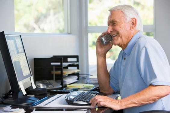 Man at computer using phone